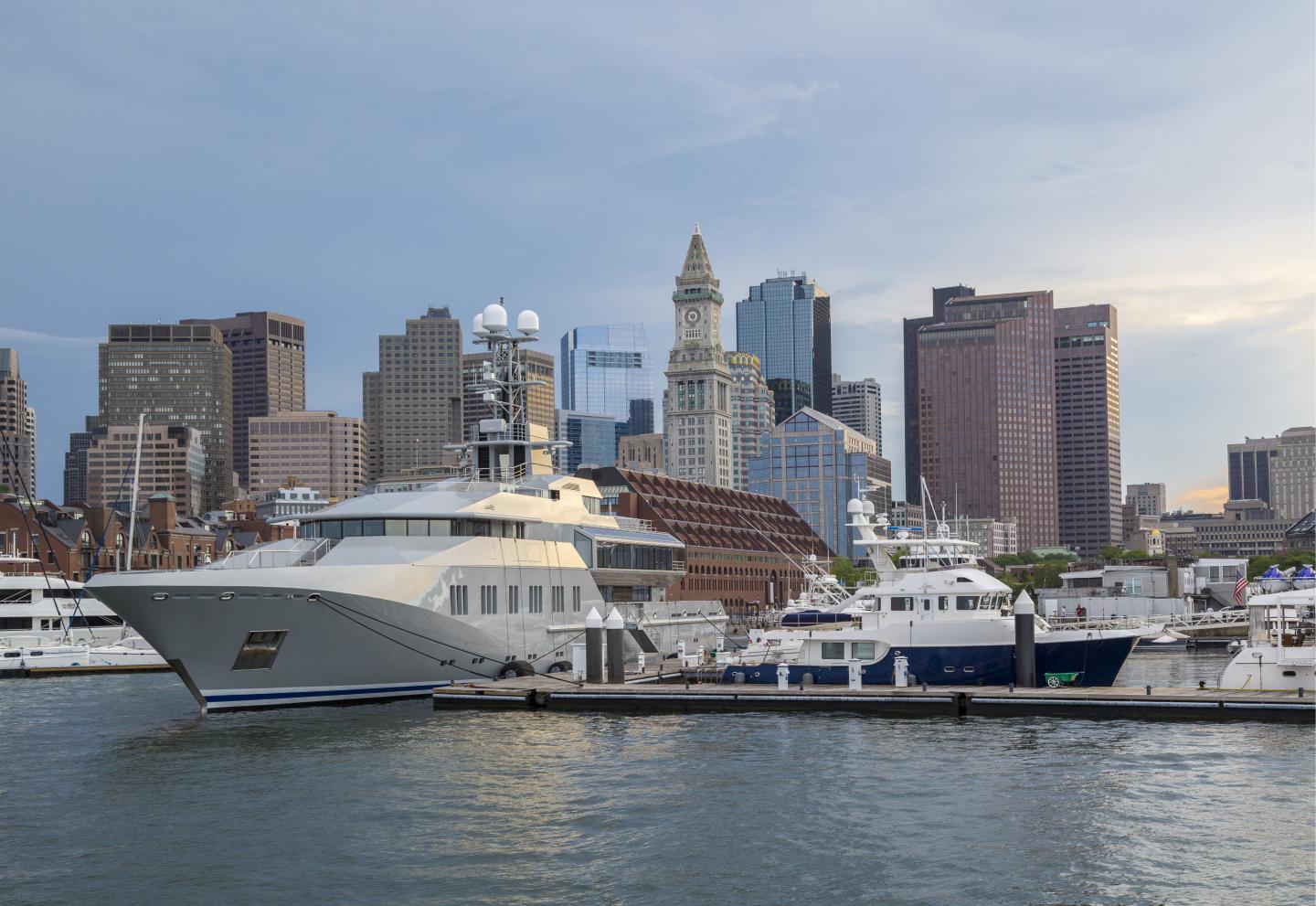 Large yacht in-front of marina, city in background
